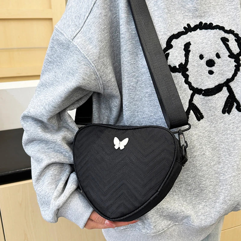 Neutral style shoulder bag for men and women, heart-shaped with butterfly-shaped decoration, suitable for travel.