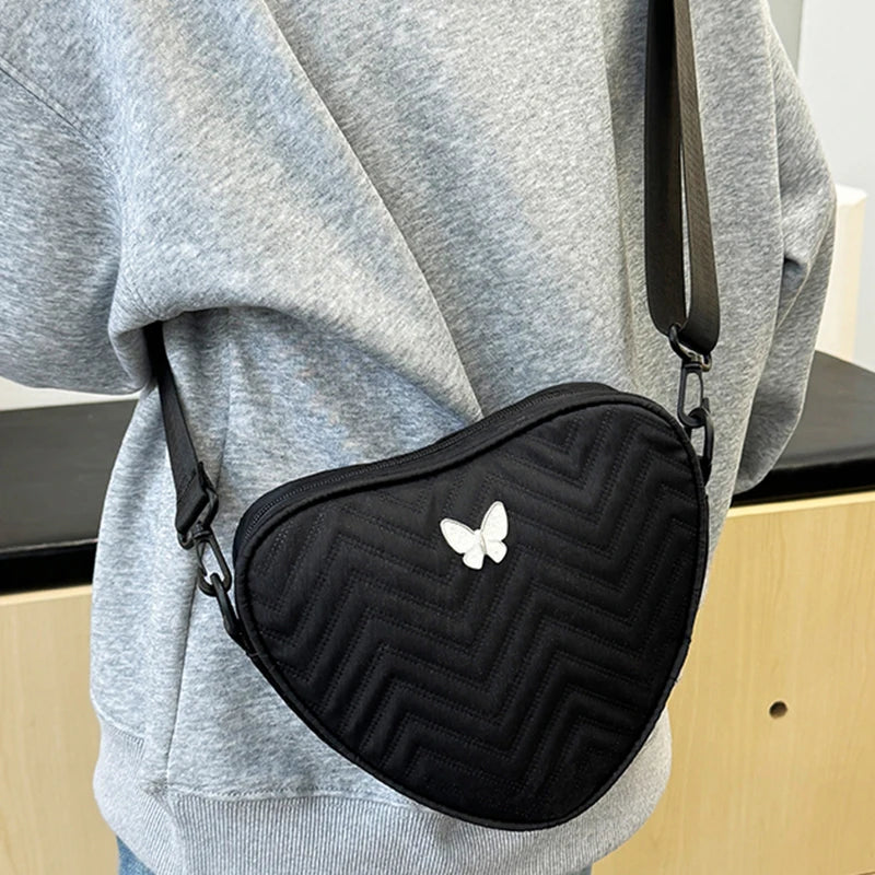 Neutral style shoulder bag for men and women, heart-shaped with butterfly-shaped decoration, suitable for travel.