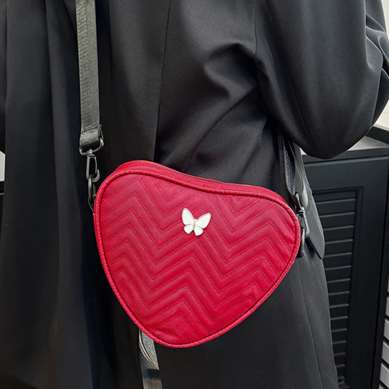 Neutral style shoulder bag for men and women, heart-shaped with butterfly-shaped decoration, suitable for travel.