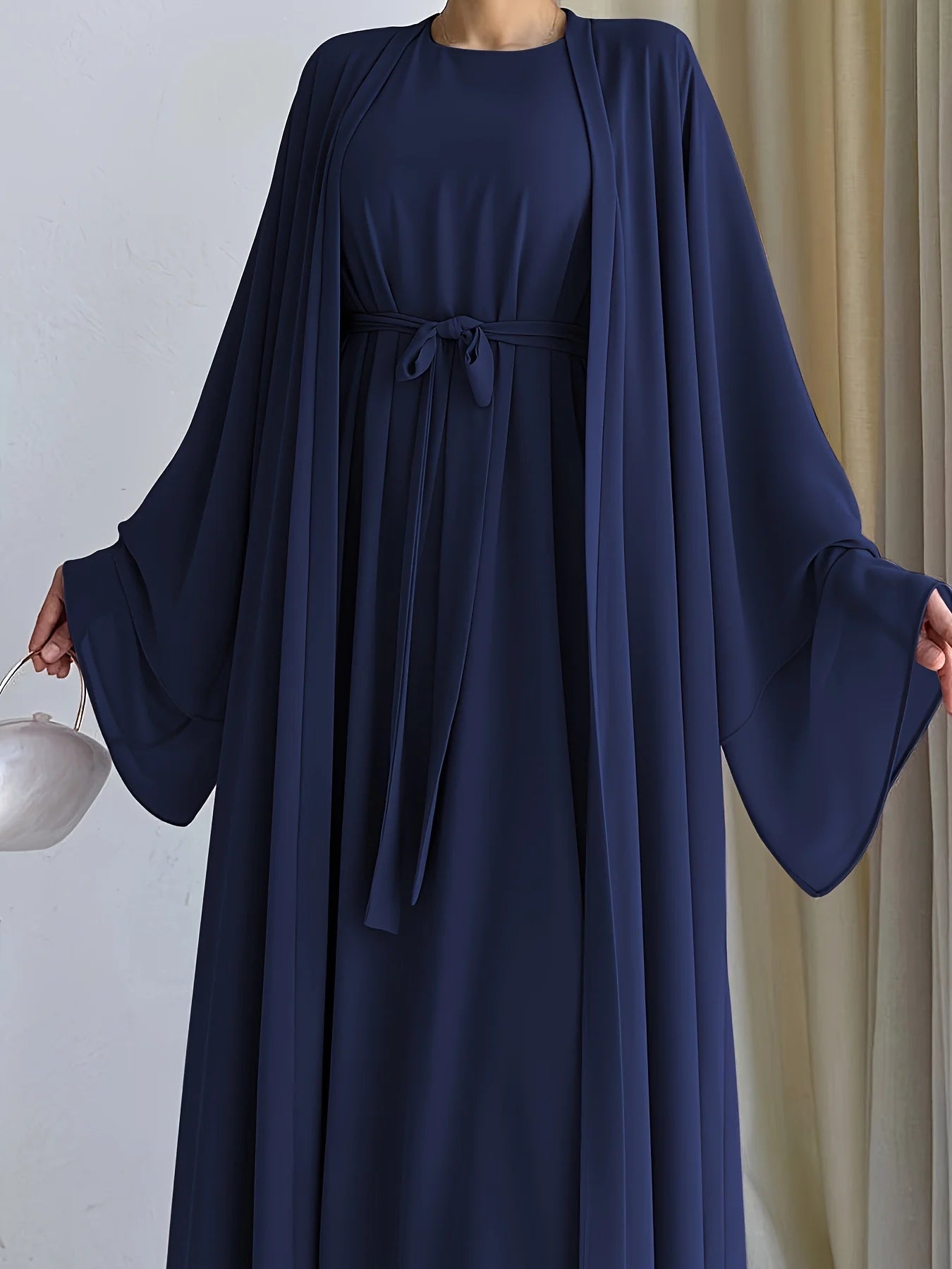 The simple and elegant Muslim robe, a two-piece outfit consisting of a vest and a wrap dress, includes a belt.