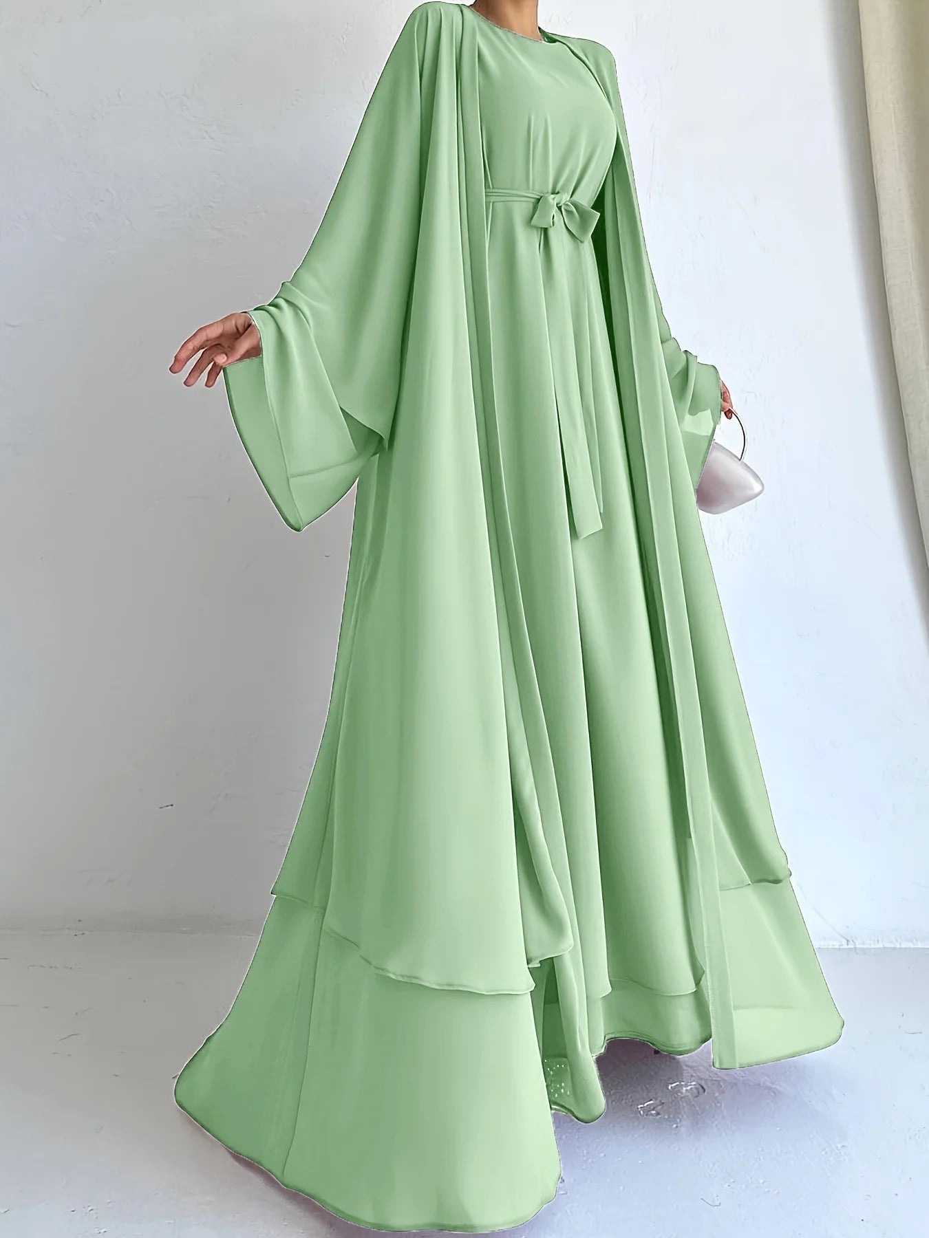 The simple and elegant Muslim robe, a two-piece outfit consisting of a vest and a wrap dress, includes a belt.